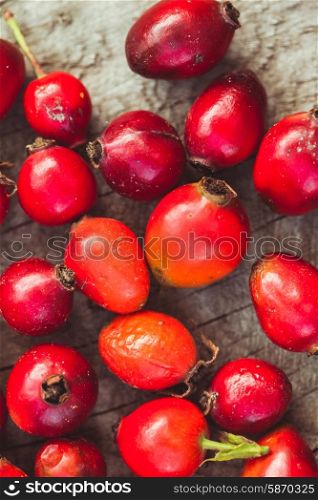 Dogrose fruits on the wooden table close up