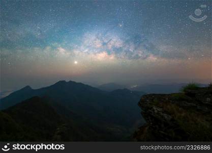 Doi Tung, Chiang Rai, Thailand with mountain hills, the milky way with bright stars on blue sky at night. Natural universe space landscape background. It is the galaxy that contains our Solar System