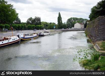 DOLE, FRANCE ? CIRCA JULY 2015 Wall of Old town and ships on the river Doubs