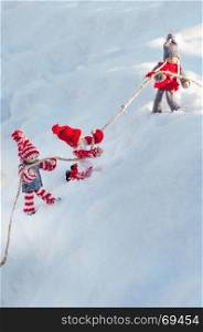 doll, toy, snow, rope, rescue, winter, white, day, child, friendship, help, danger, slopethree wooden dolls on a snowy slope clinging to a rope on a winter day