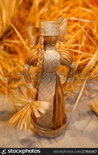 Doll woven from straw. Antique toys, souvenirs. Close-up.