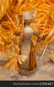 Doll woven from straw. Antique toys, souvenirs. Close-up.