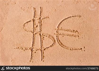 dollar and euro symbols drawn on the sand