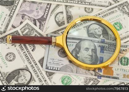 dollar banknotes under magnifying glass