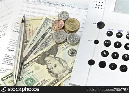 Dollar bills, calculator and 1040 tax return form. US Federal Income Tax Forms