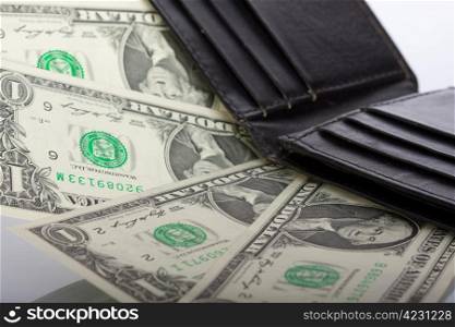 dollar bills in black leather wallet on abstract background