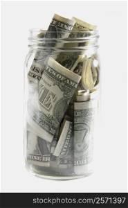 Dollar bills squashed into a jar