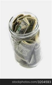 Dollar bills squashed into a jar