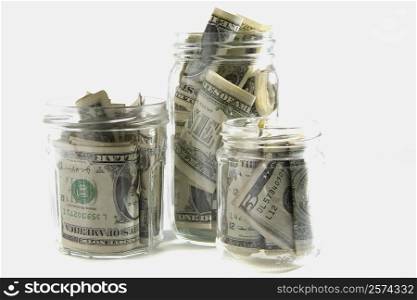 Dollar bills squashed into three jars