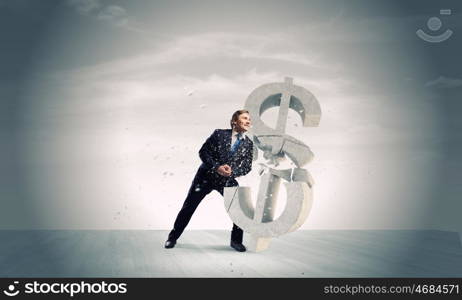Dollar fall. Young businessman breaking stone dollar sign. Currency concept