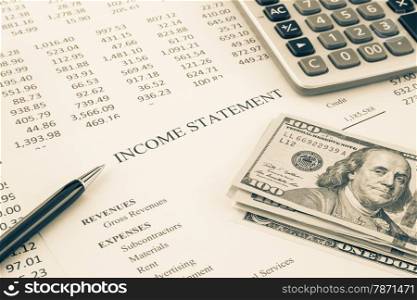 Dollar money place on business income statement with detail list of revenues and expenses, accounting reports on background, sepia tone image
