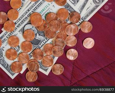 Dollar notes and coin, United States over red velvet background. One Dollar banknotes and One Cent coin money (USD), currency of United States over crimson red velvet background