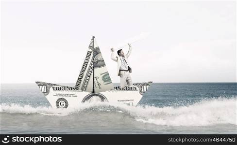 Dollar paper boat. Businessman in ship of dollar banknote floating on water