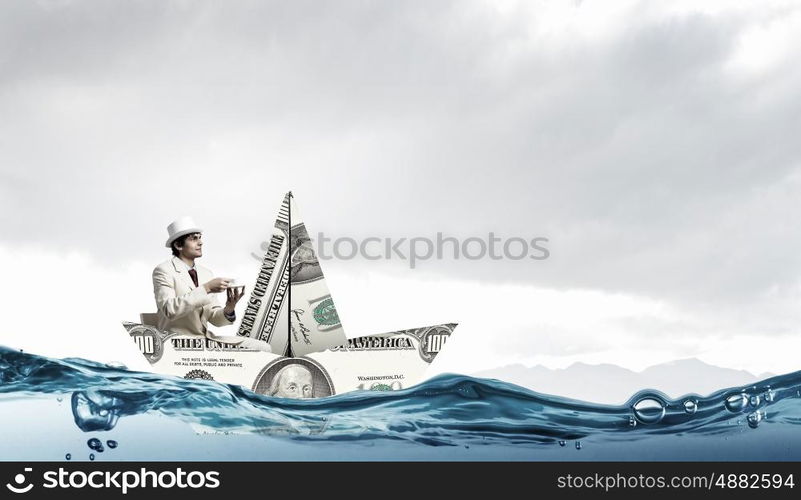 Dollar paper boat. Businessman in ship of dollar banknote floating on water