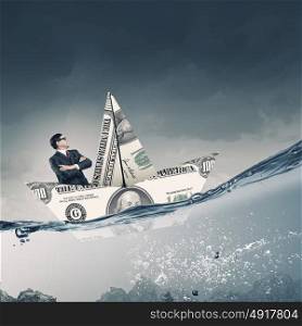 Dollar paper boat. Businessman in ship of dollar banknote floating on water