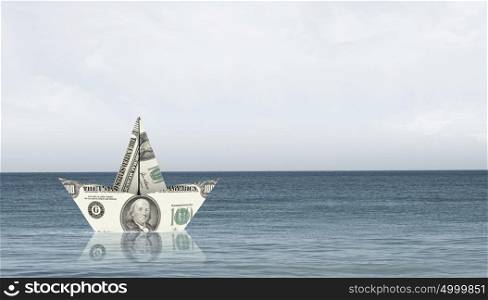 Dollar paper boat. Ship of dollar banknote floating on water