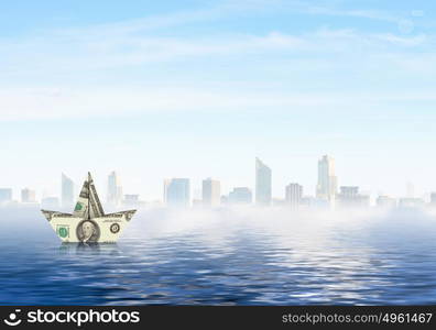 Dollar ship in water. Ship made of dollar banknote floating in water