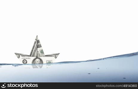 Dollar ship. Ship made of dollar banknote floating in water