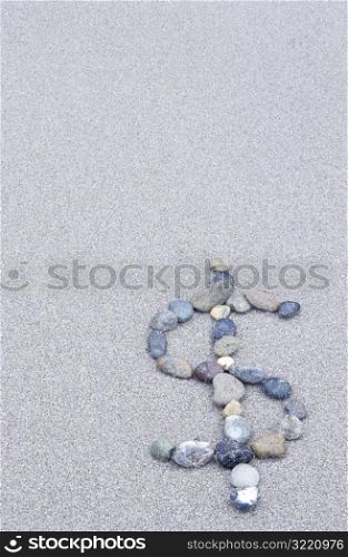 Dollar Sign in Stones on the Beach