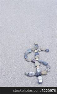 Dollar Sign in Stones on the Beach