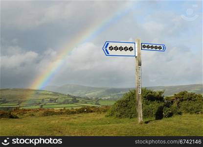 Dollar symbols on signpost. Focus on signpost in foreground.