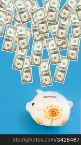 Dollars coming into piggy bank (moneybox).
