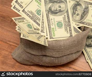 dollars in a sack on wooden background