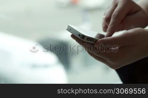 Dolly close-up shot of womans hands typing text message on smart phone