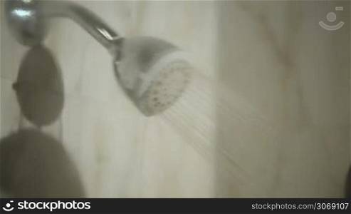 Dolly shot of a young woman getting pleasure from taking a shower