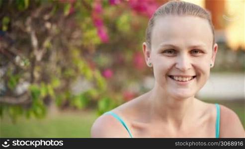Dolly shot of pretty happy woman. Young female with kind and charming smile on summer background
