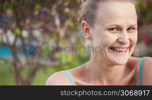 Dolly shot of smiling woman. Pretty female winking and looking coquettish