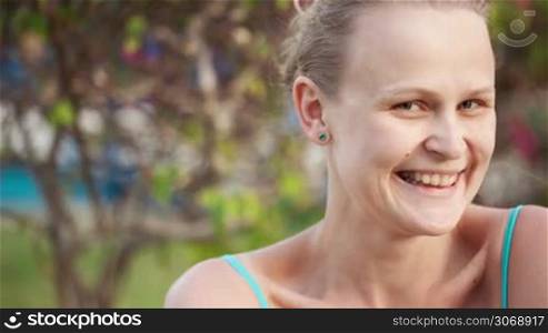 Dolly shot of smiling woman. Pretty female winking and looking coquettish