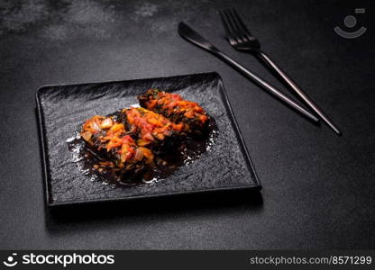 Dolma, stuffed grape leaves with rice and meat on a dark background. Caucasian and Turkish cuisine. Dolma, stuffed grape leaves with rice and meat on a dark background