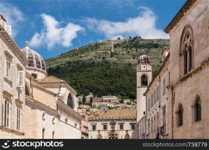 Dome on St Blaise church and bell tower in the old town of Dubrovnik in Croatia. Hillside rises above the bell tower in Dubrovnik old town