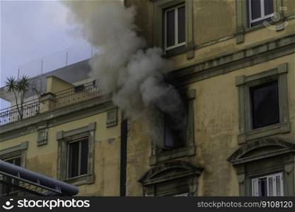 Domestic apartment fire with smoke billowing from window. Garibaldi Square, Naples, Italy, landscape