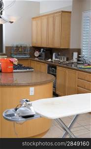 Domestic kitchen with ironing board and an iron