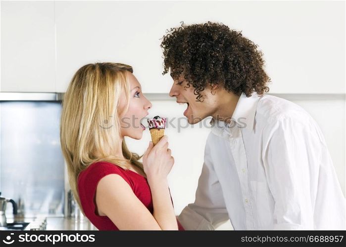 domestic life: interracial couple eating an ice cream