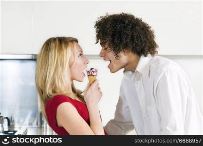 domestic life: interracial couple eating an ice cream