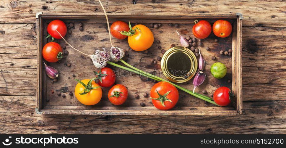 domestic pickle tomato. tomato,pepper peas and garlic for pickling in retro wooden box