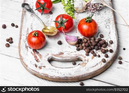 domestic pickle tomato. tomato,peppercorn and garlic for pickling on white kitchen board