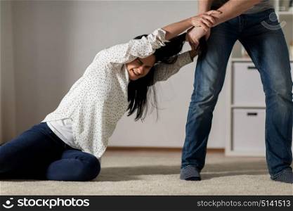 domestic violence, abuse and people concept - couple having fight and man dragging helpless woman by hair at home. unhappy woman suffering from home violence