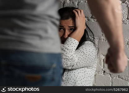 domestic violence, abuse and people concept - man beating helpless scared woman. unhappy woman suffering from domestic violence