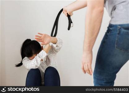domestic violence, abuse and people concept - man beating helpless scared woman with belt. unhappy woman suffering from domestic violence