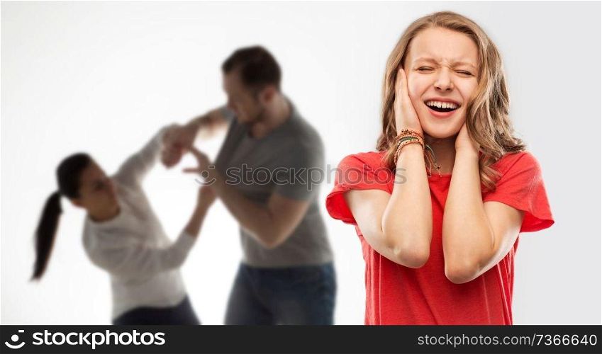 domestic violence, assault and social issue concept - unhappy stressed teenage girl covering her ears when her mother and father having fight background. girl covering ears over her parents having fight