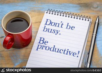 Don't be busy. Be productive. Handwriting in a spiral notebook with a cup of coffee.