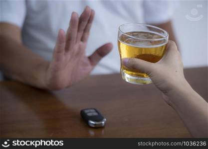 Don&rsquo;t drink drive and Man refusing alcohol beer showing car key as gesture of don&rsquo;t drink and drive