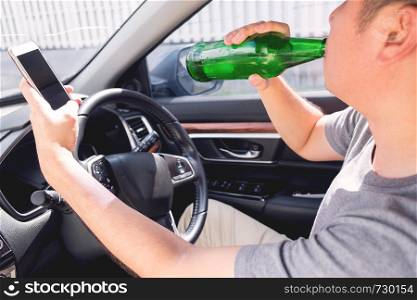 Don't Drink for Drive concept, Young Drunk man drinking bottle of beer or alcohol during driving the car dangerously.