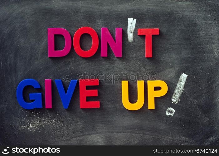Don&rsquo;t give up - text made of colorful letters on a smudged blackboard