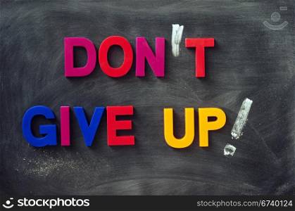 Don&rsquo;t give up - text made of colorful letters on a smudged blackboard