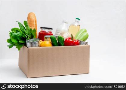 Donation Box with Supplies Food for People in Isolation on Light Background. Essential Goods: Oil, Canned Food, Cereals, Milk, Vegetables, Fruit.. Donation Box with Supplies Food for People in Isolation on Light Background. Essential Goods: Oil, Canned Food, Cereals, Milk, Vegetables, Fruit